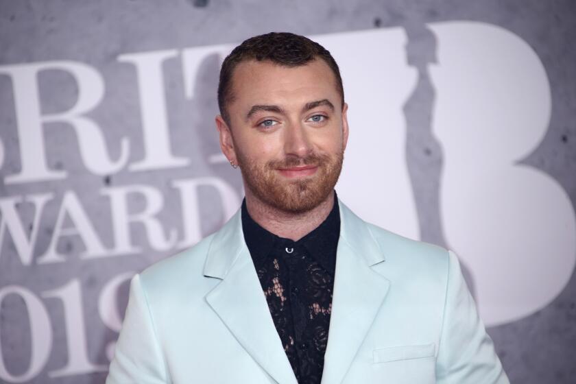 Sam Smith posing in a light blue suit