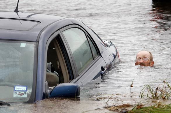 A man tries to recover a car that was swept away in flooding on Galveston Island caused by Hurricane Ike.