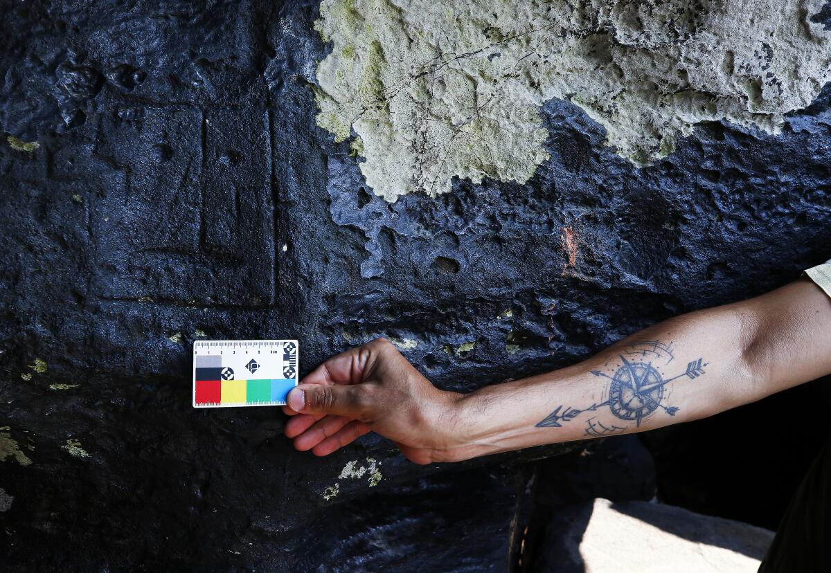 An archaeologist measures rock paintings at the Ponta das Lajes archaeological site, in the rural area of Manaus, Brazil.