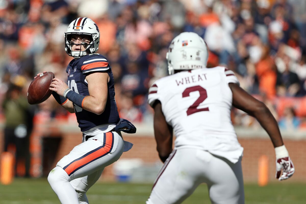 Auburn quarterback Bo Nix (10) throws a pass as Mississippi State linebacker Tyrus Wheat (2) brings pressure during the first half of an NCAA college football game Saturday, Nov. 13, 2021, in Auburn, Ala. (AP Photo/Butch Dill)