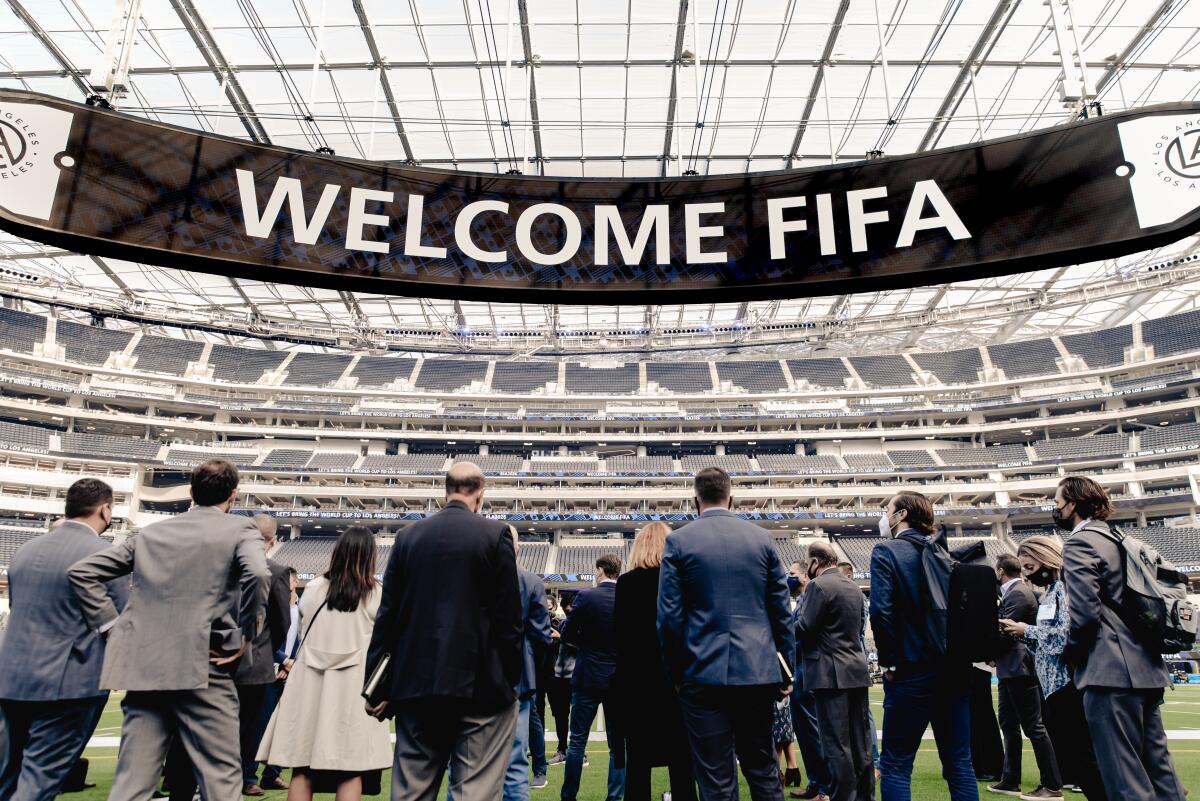 A 21-member FIFA delegation stands on the field at SoFi Stadium.