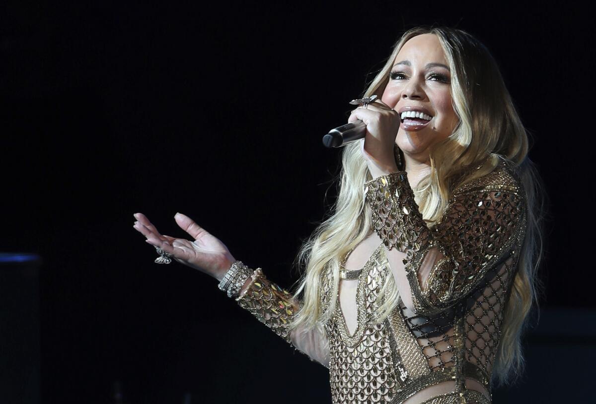 Mariah Carey sings into a microphone