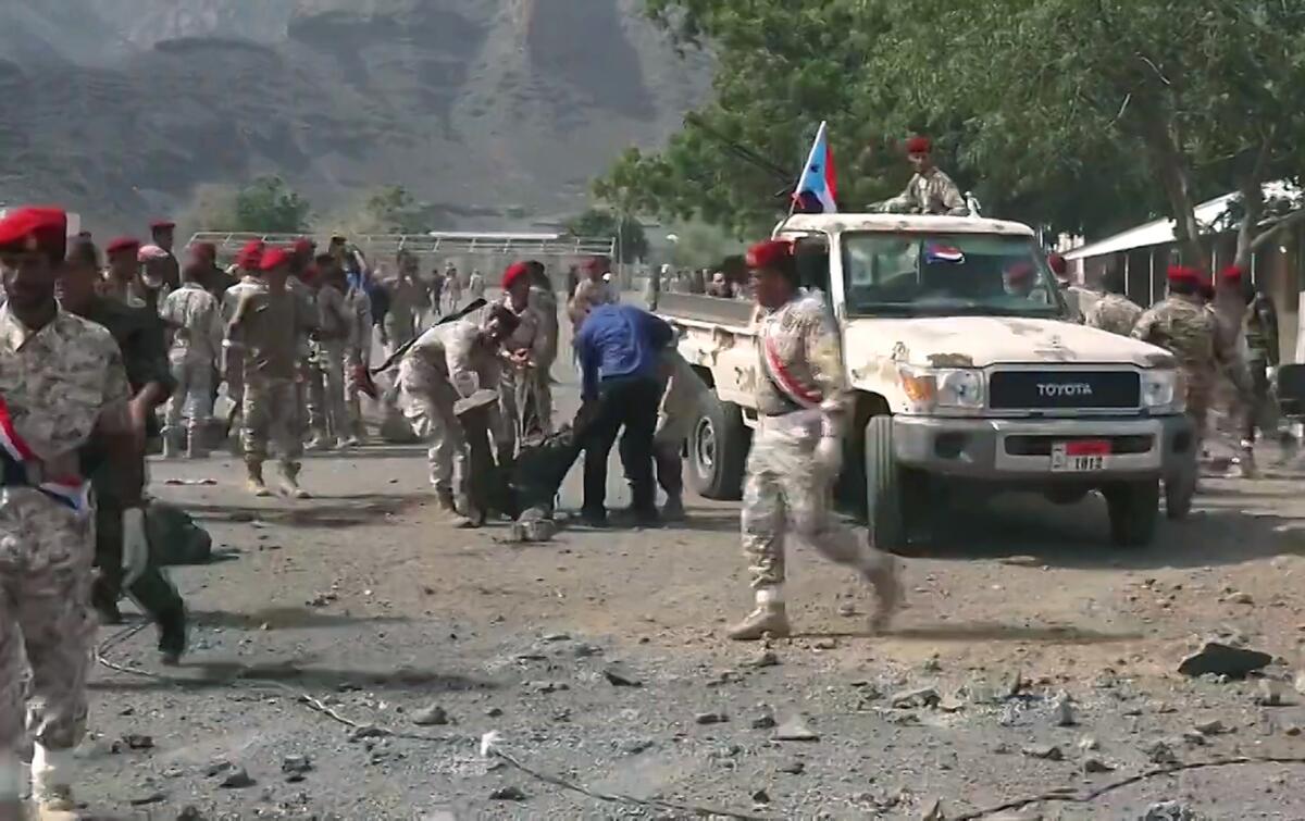 This AFPTV screen grab from a video made on Thursday shows Yemeni security forces carrying a body at the scene of a missile attack on a military camp west of Yemen's southern port city of Aden.