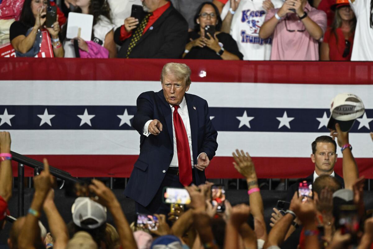 Republican presidential candidate former President Donald Trump points to supporters at a rally