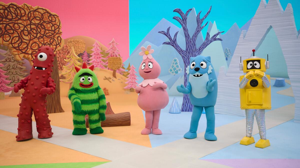 Four colorful monsters and a yellow robot stand in diorama of the seasons.