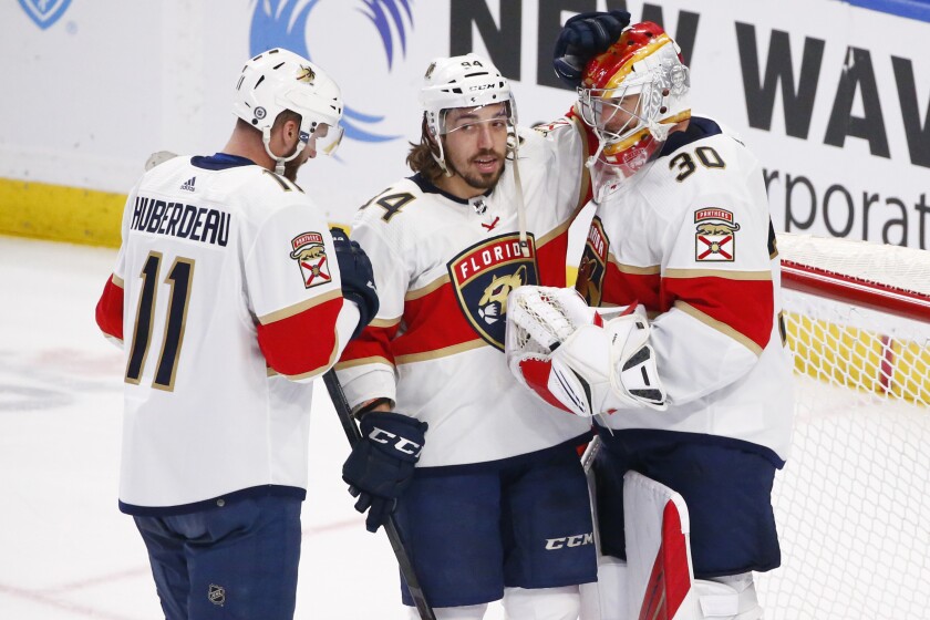 Florida Panthers left wing Jonathan Huberdeau (11) and left wing Ryan Lomberg (94) celebrate a victory with goaltender Spencer Knight (30) following the third period of an NHL hockey game against the Buffalo Sabres, Sunday, April 3, 2022, in Buffalo, N.Y. (AP Photo/Jeffrey T. Barnes)