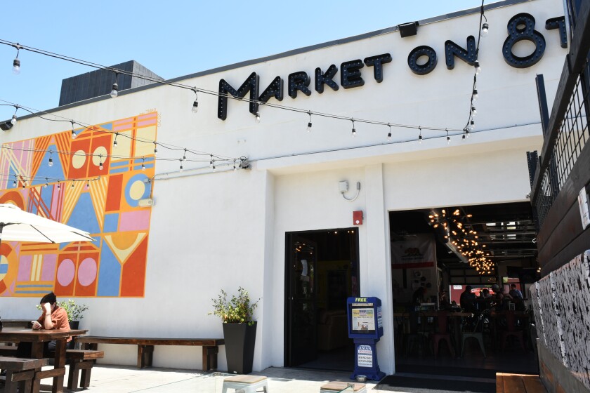 Patrons sit on the rear patio and others enjoy meals indoors at Market on 8th in National City on Tuesday, Aug. 16, 2022.