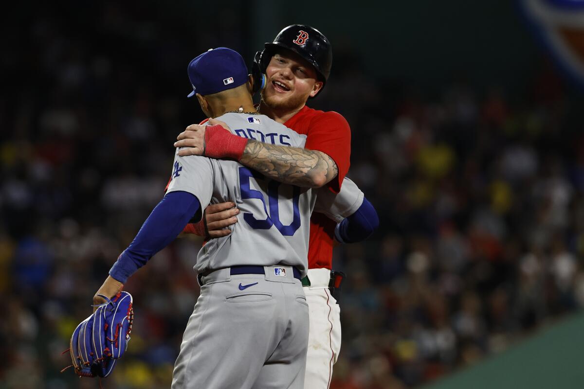 Red Sox's Alex Verdugo and Dodgers' Mookie Betts hug during a game on Aug. 25, 2023, at Fenway Park.