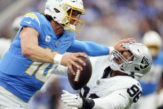 Los Angeles Chargers quarterback Justin Herbert (10) stiff-arms Las Vegas Raiders defensive end Isaac Rochell during the first half of an NFL football game Sunday, Oct. 1, 2023, in Inglewood, Calif. (AP Photo/Ryan Sun)