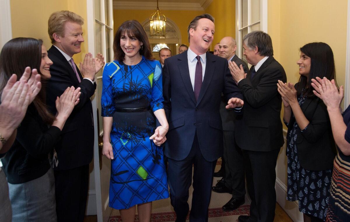 Britain's Prime Minister David Cameron and his wife Samantha are applauded by staff upon entering 10 Downing Street in London on May 8 following the Conservative Party's election victory.
