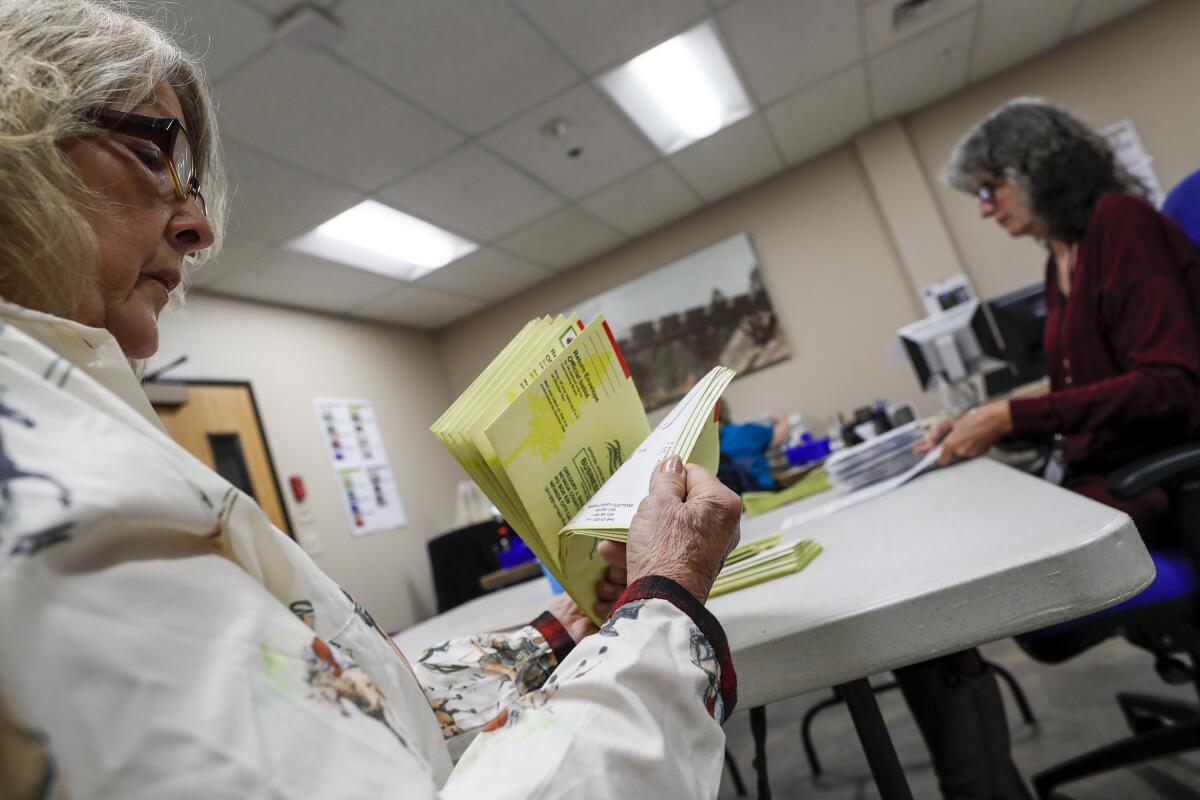 Poll workers look through ballots.