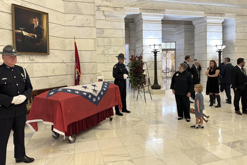 Barbara Pryor, the widow of former Arkansas governor and U.S. Sen. David Pryor, stands before Pryor's casket with their great-grandson Raven at the Arkansas state Capitol in Little Rock, Arkansas on Friday, April 26, 2024. David Pryor died in Little Rock on April 20, 2024. Pryor, a Democrat, remained active in public service long after he left public office. (AP Photo/Andrew DeMillo)