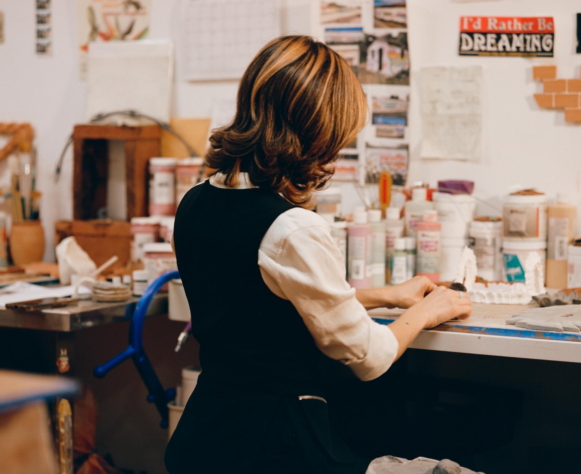 Lizette Herández seated at the desk in her studio