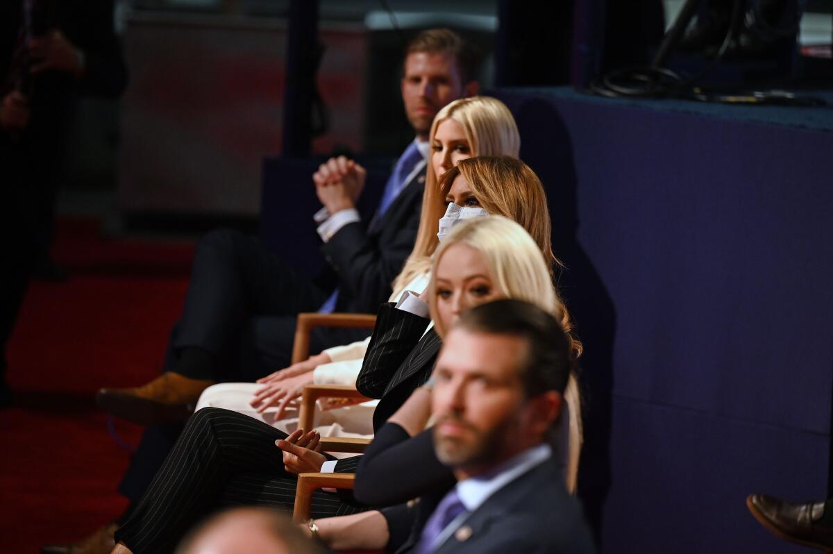 President Trump's offspring sit at the Cleveland debate without masks. Melania Trump, center, is wearing one. 
