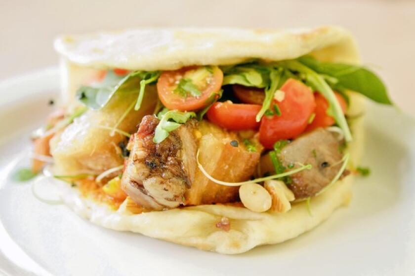 The original baco, a flatbread sandwich, filled with pork belly and beef carnitas.