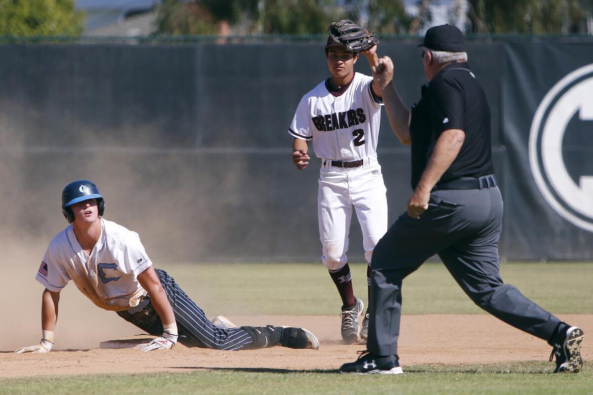 Laguna Beach's Taylor Towe (2) gets the call at second base against Corona del Mar's Max Lane, left, in a Wave League game.