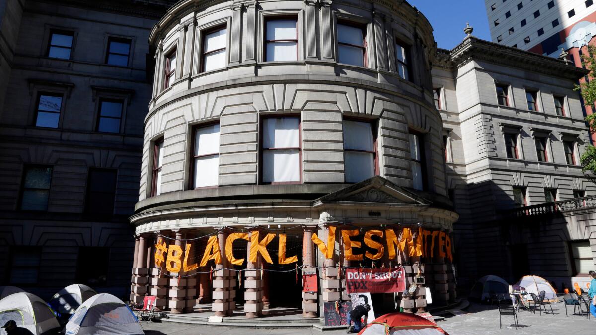 Large letters spell out "Black Lives Matter" on the portico at Portland City Hall after the building was shut down in response to a protest.