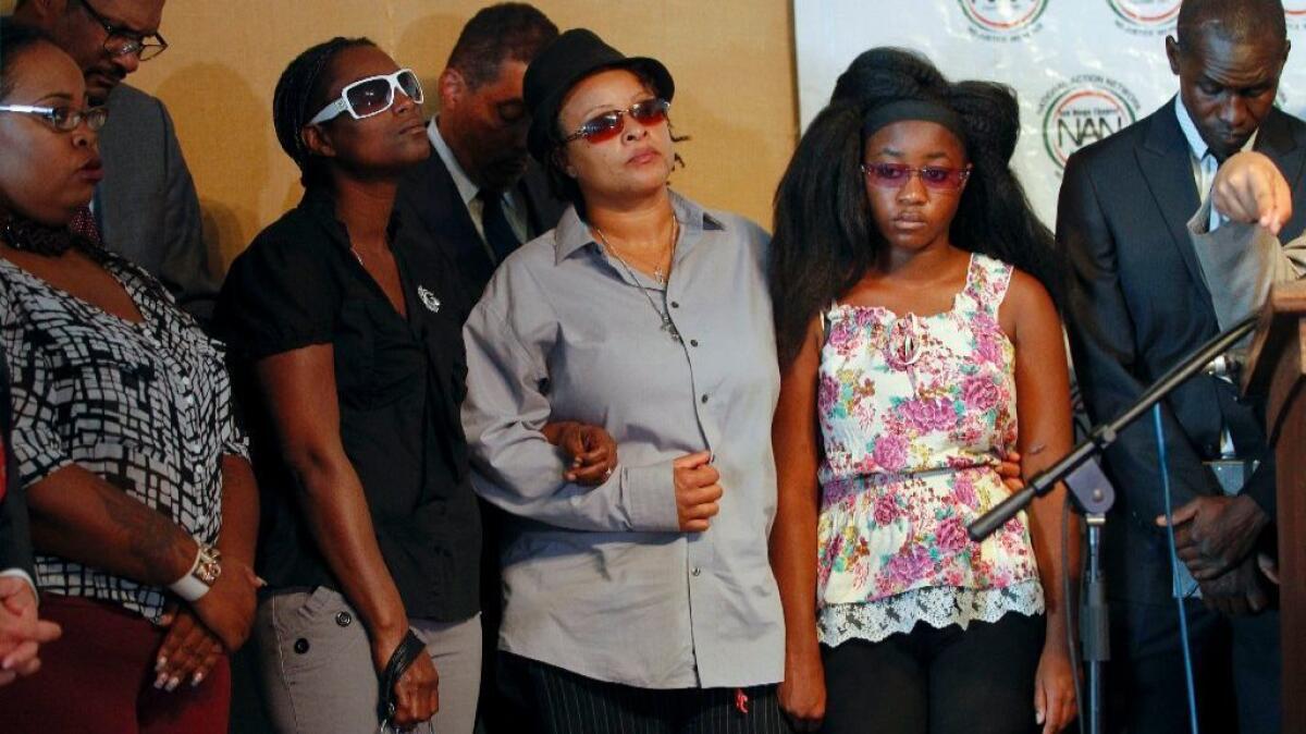 Alfred Olango's widow, Taina Rozier, center, and 16-year-old daughter, second from right, appear at news conference in San Diego on Thursday. Olango was killed by police in September.