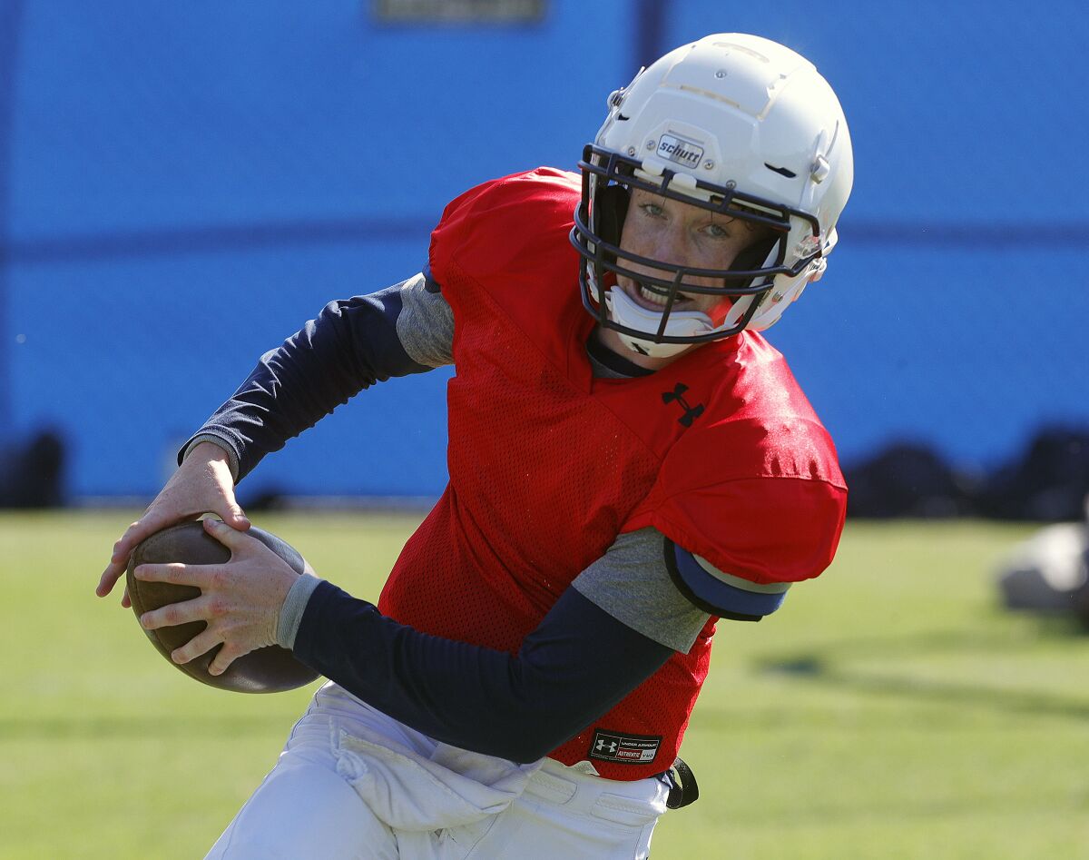 Flintridge Prep's quarterback Max Gitlin runs with the the ball while practicing a play at pre-season football practice at Flintridge Prep on Monday, August 19, 2019.