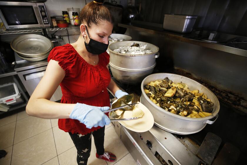 OXNARD, CA - NOVEMBER 30: Griselda Vega displays some of her selection of tamales at Ocho Regiones Restaurant located at 333 Cooper Road in Oxnard which is taking part in the reimagined 14th Annual Oxnard Tamale Festival. The festival has been going on for 14 years, but last year and this year, it's been limited to just four participants, split up over 4 different days. Ocho Regiones on Tuesday, Nov. 30, 2021 in Oxnard, CA. (Al Seib / Los Angeles Times).