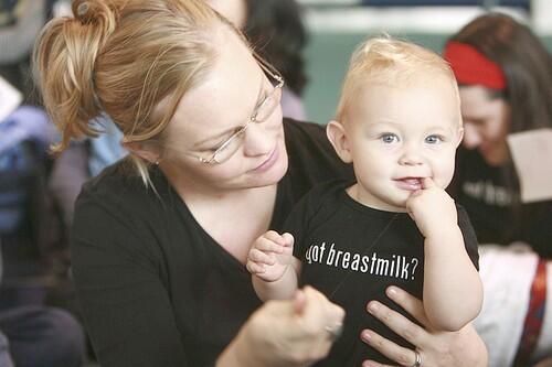 Max Parris, right, sports a "Got breastmilk?" shirt and a smile in the arms of his mother, Ellie Parris, Tuesday at Portland International Airport.