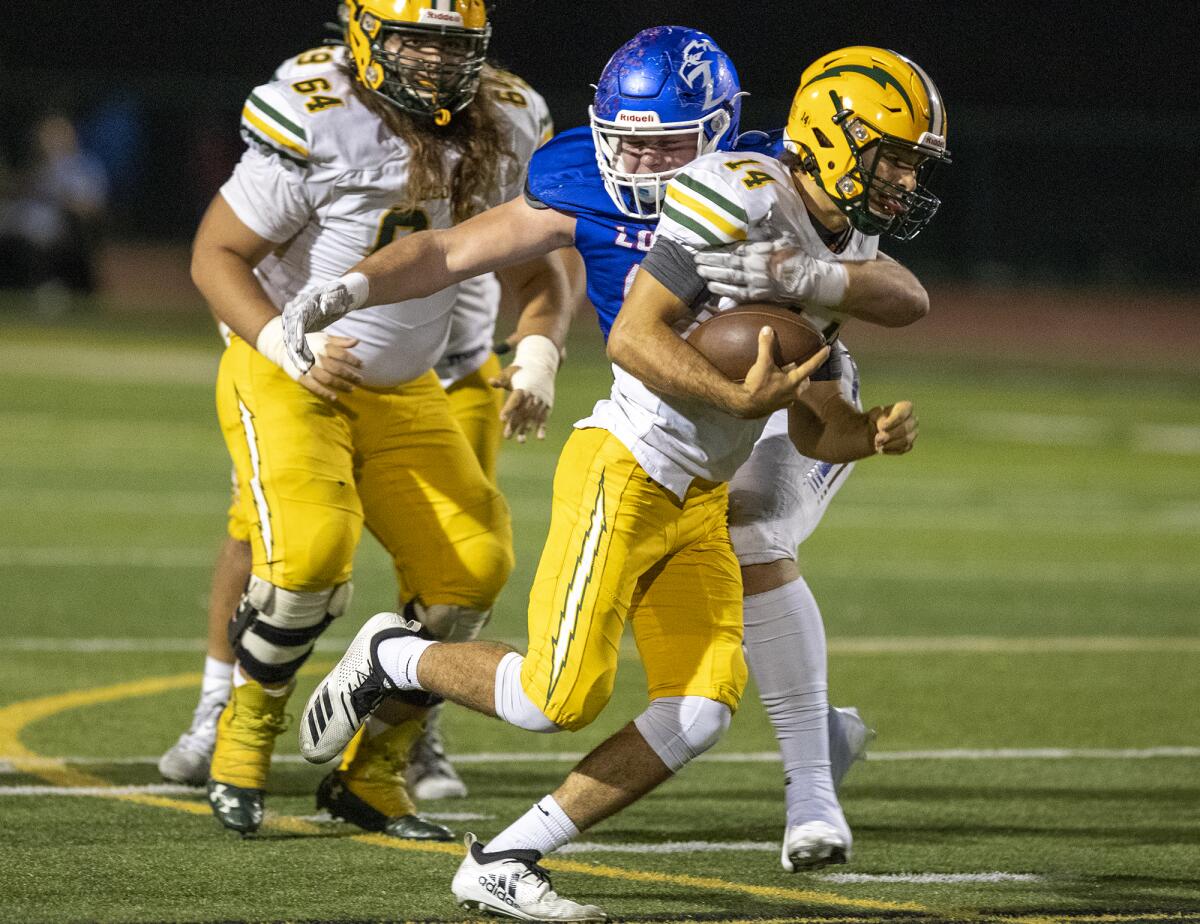 Los Alamitos' Eric Gage tackles Edison's Parker Awad during a Sunset League game at Boswell Field on Thursday.