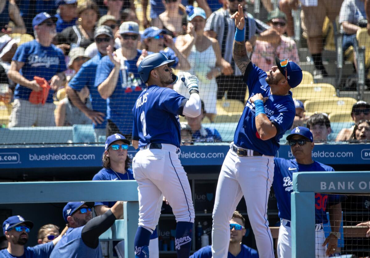 Dodgers shortstop Miguel Rojas, left, celebrates his solo homer with teammate David Peralta.