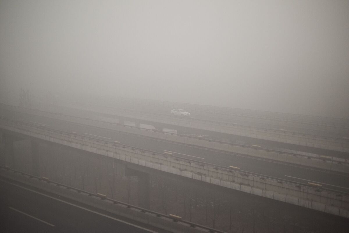 A car drives along a highway on a polluted day in Beijing on December 1, 2015. China has ordered thousands of factories to shut as it grapples with swathes of choking smog that were nearly 24 times safe levels on December 1, casting a shadow over the country's participation in Paris climate talks. A thick grey haze shrouded Beijing, with the concentration of PM 2.5, harmful microscopic particles that penetrate deep into the lungs, climbing as high as 598 micrograms per cubic metre AFP PHOTO / FRED DUFOURFRED DUFOUR/AFP/Getty Images ** OUTS - ELSENT, FPG, CM - OUTS * NM, PH, VA if sourced by CT, LA or MoD **