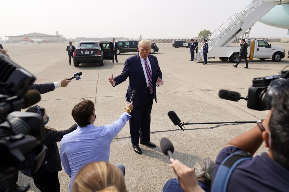 President Trump speaks to reporters as he arrives at Sacramento McClellan Airport for a briefing on wildfires. 