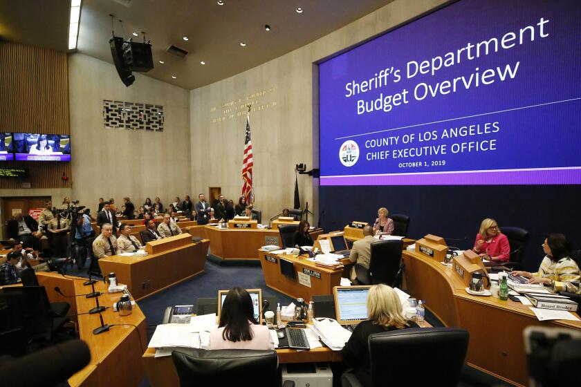 LOS ANGELES, CA - OCTOBER 01, 2019 Los Angeles County Sheriff Alex Villanueva, left, seated with Undersheriff Tim Murakami, second-in-command as they listen during the Los Angeles County Board of Supervisors meeting to proposals regarding spending at the Sheriff’d Department in an effort to recover a $63 million budget deficit. (Al Seib / Los Angeles Times)