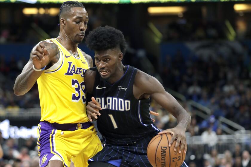 Orlando Magic's Jonathan Isaac (1) looks for a path to the basket against Los Angeles Lakers' Dwight Howard, left, during the second half of an NBA basketball game, Wednesday, Dec. 11, 2019, in Orlando, Fla. (AP Photo/John Raoux)