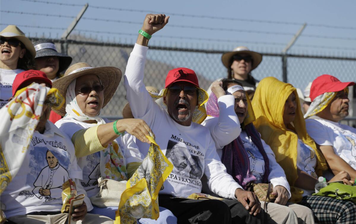 Migrants gathered in El Paso near the Rio Grande cheer as they wait to see Pope Francis appear on the other side of the border in Ciudad Juarez, Mexico, on Feb. 17.