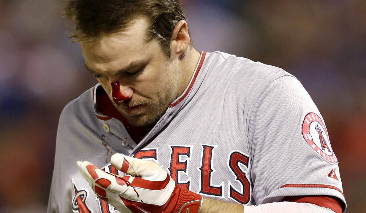 Blood gushes from the nose of Angels outfielder Collin Cowgill after he foul-tipped a pitch during the eighth inning of a game against the Rangers on Saturday night in Arlington, Texas.