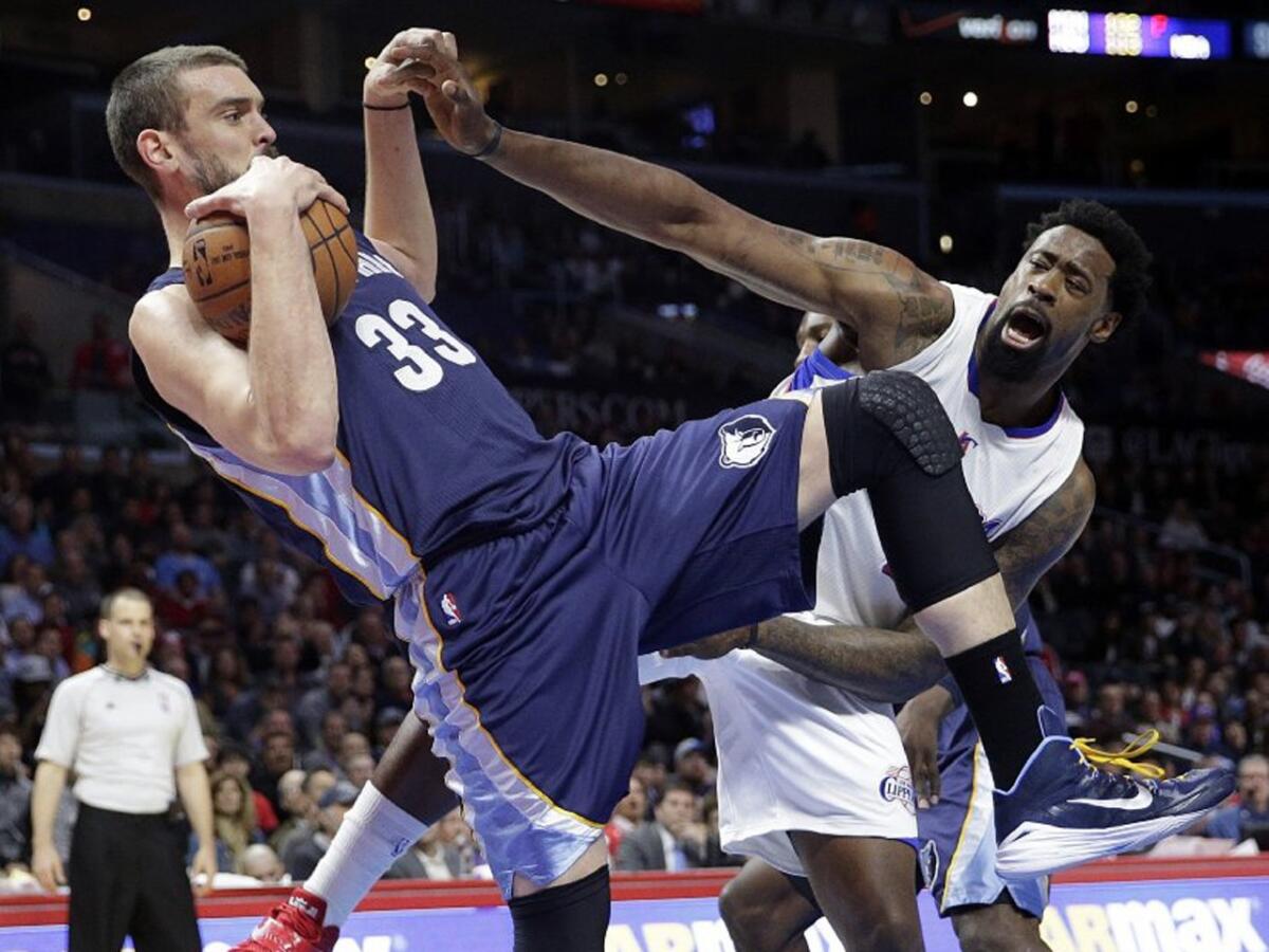 Grizzlies center Marc Gasol pulls down a rebound and holds Clippers center DeAndre Jordan's hand.