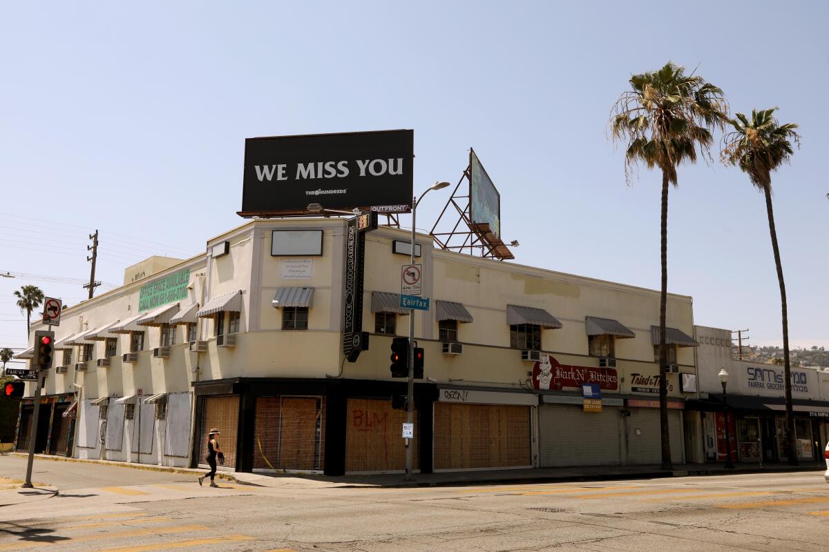 A billboard above Bobby Kim's the Hundreds store, which is now boarded up, states, "We Miss You."