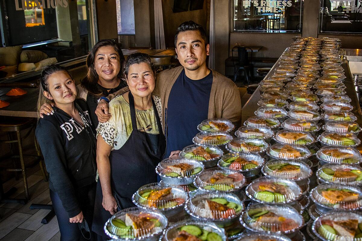 Nhi Huynh, Huong Pham, Kim Huynh and Viet Pham in their restaurant with about 600 packaged Han Vi meals they prepared