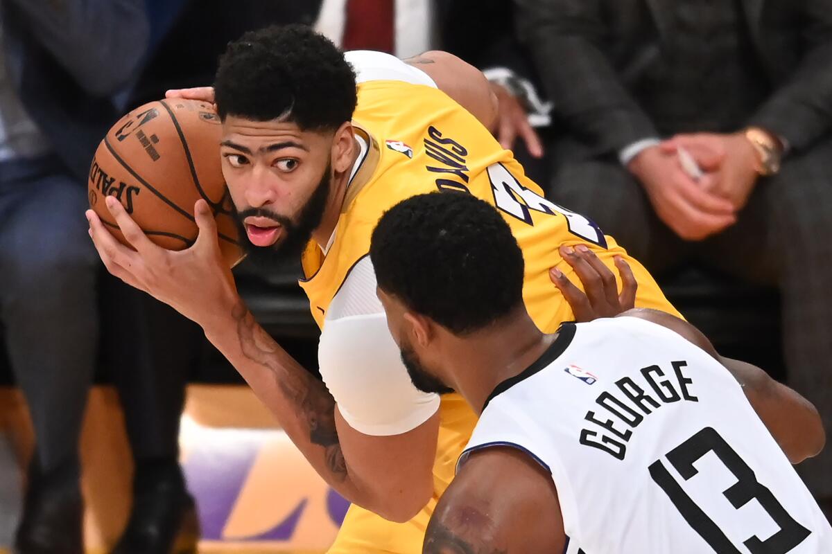 Lakers forward Anthony Davis is guarded by Clippers forward Paul George during the Clippers' win on Christmas Day.