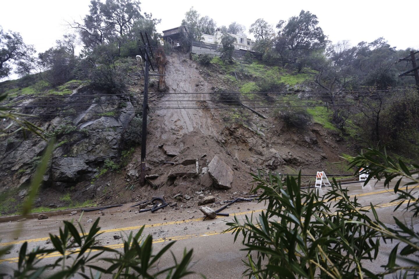 Laurel Canyon Boulevard remained closed in both directions Thursday morning in the Hollywood Hills after part of a home's concrete foundation tumbled down a hillside after a round of rainfall.