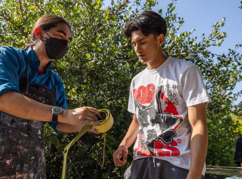 A man shows another native plants.