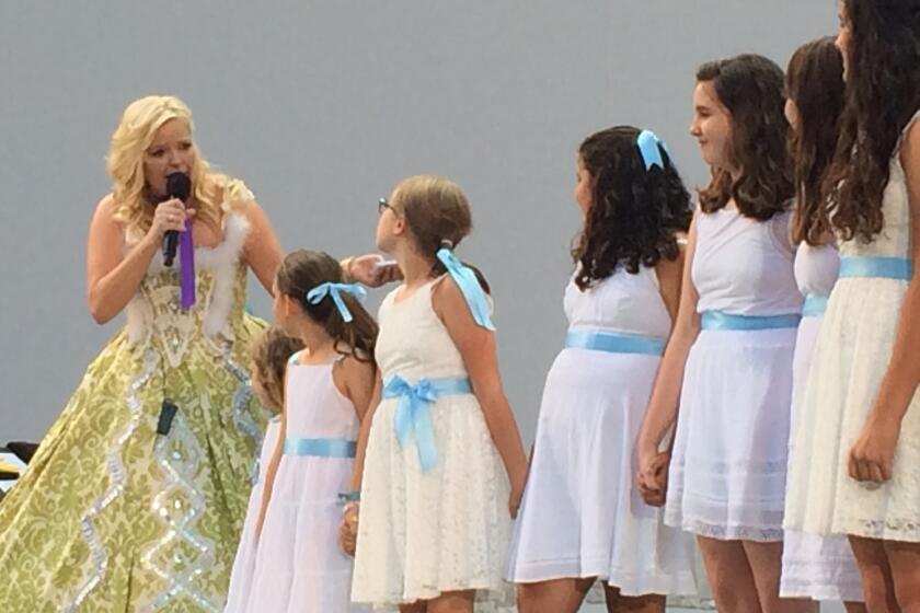 Pre-show host Melissa Peterman with girls in white dresses with blue satin sashes at the Hollywood Bowl's "Sound of Music" sing-along on Friday.