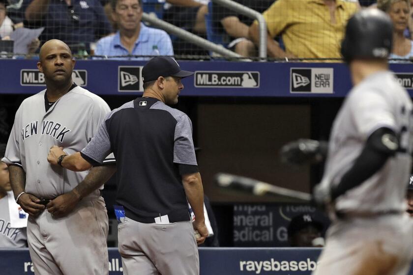 New York Yankees manager Aaron Boone, center, restrains starting pitcher CC Sabathia, left, after Tampa Bay Rays pitcher Andrew Kittredge threw behind Yankees batter Austin Romine, right, during the sixth inning of a baseball game Thursday, Sept. 27, 2018, in St. Petersburg, Fla. (AP Photo/Chris O'Meara)