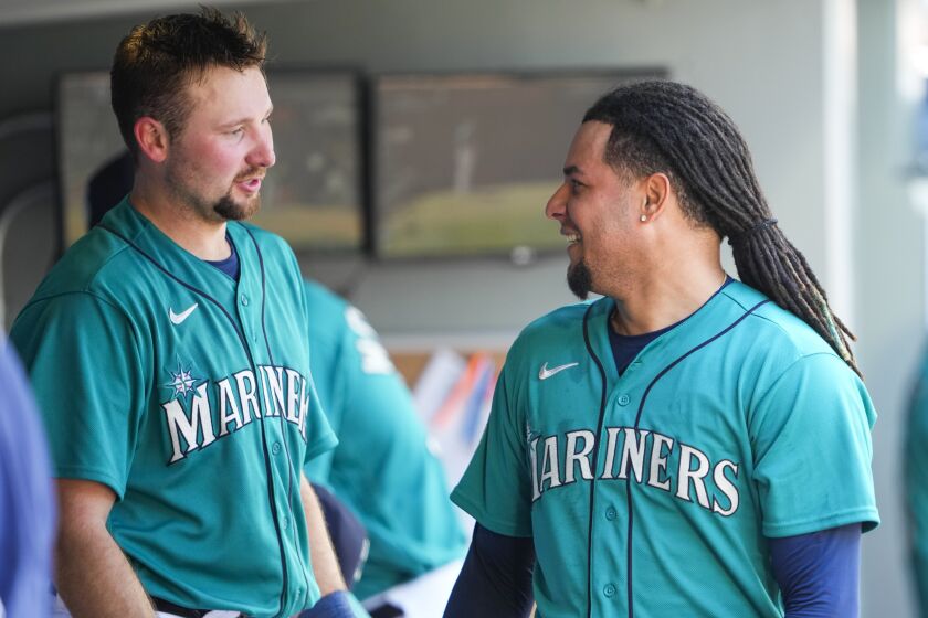 Seattle Mariners' Cal Raleigh, left, talks with starting pitcher Luis Castillo, right, after Castillo pitched through six innings against the Pittsburgh Pirates in a baseball game Saturday, May 27, 2023, in Seattle. (AP Photo/Lindsey Wasson)