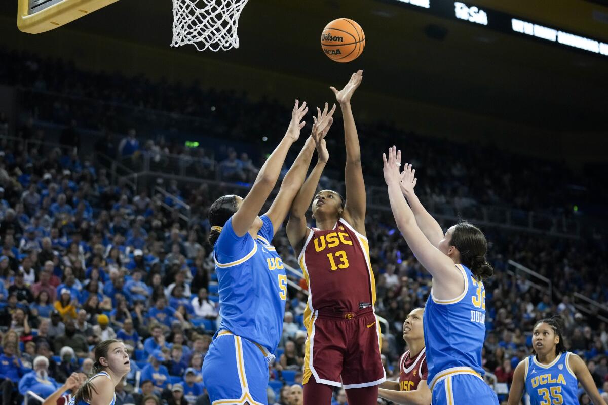 USC center Rayah Marshall shoots between UCLA's Lauren Betts and Angela Dugalic.