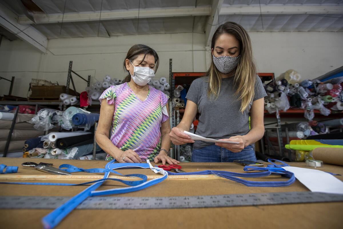 Jenny Farrell, right, with OC Cutworks, and her mother Preechar Sullivan work on a pattern to create face masks for UC Irvine healthcare workers.
