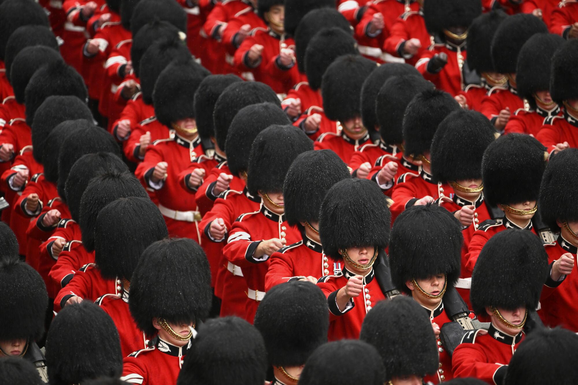Scots and Welsh Guards march on the procession route in dense formation.
