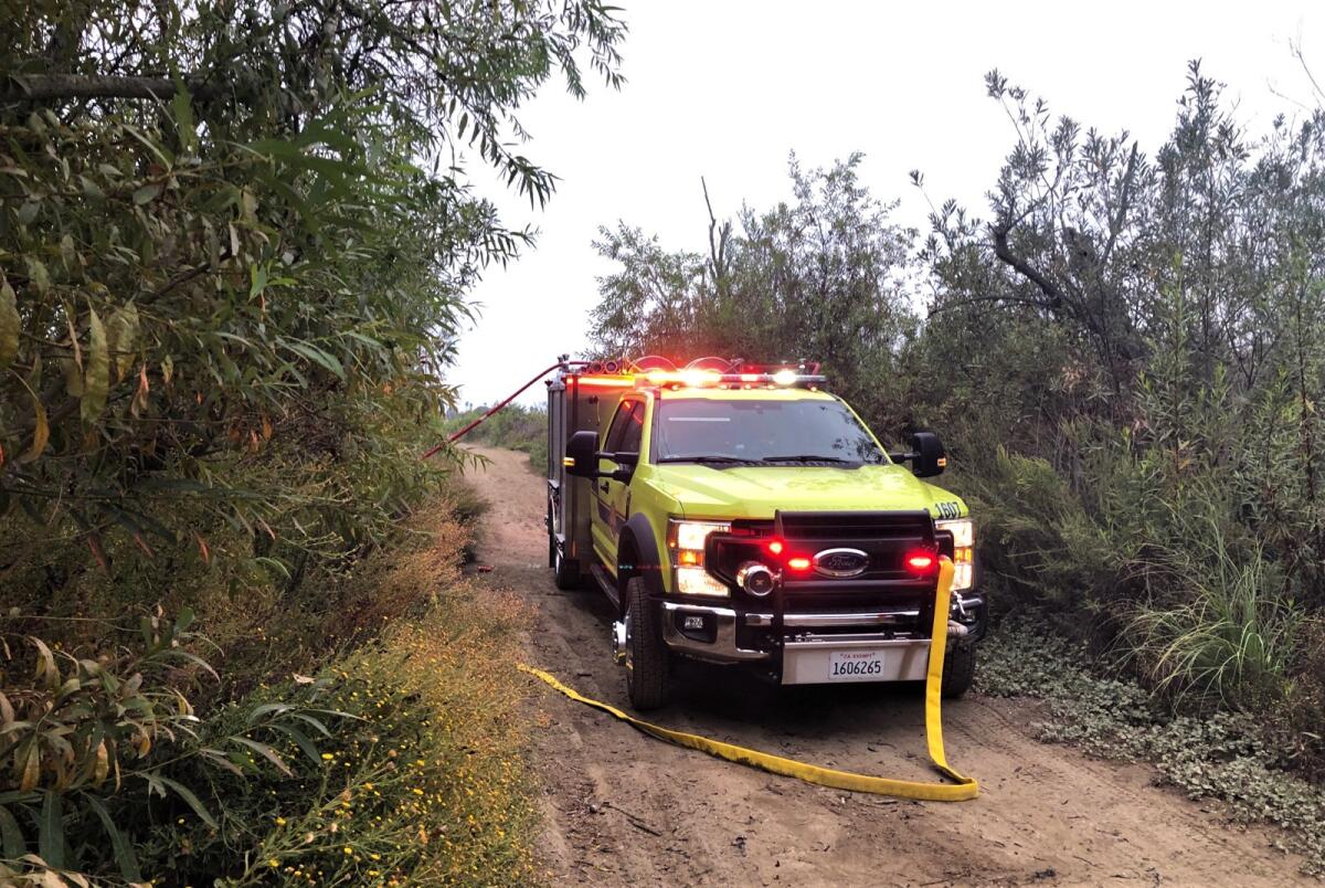 Firefighters on Tuesday ran 1,200 feet of hose line into Talbert Park to battle a brush fire that broke out after 6 a.m.