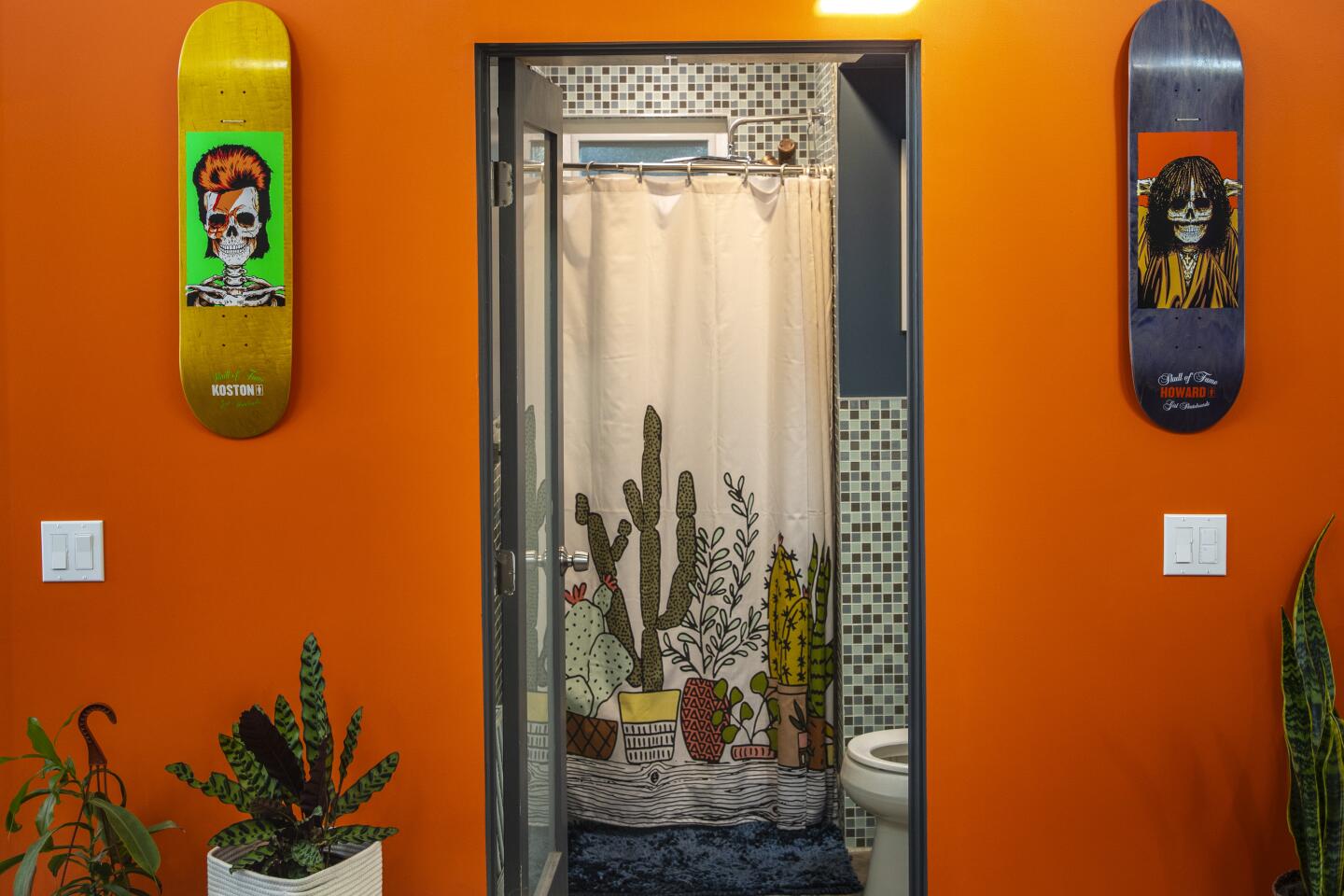 The bathroom door is set in a bright orange wall.