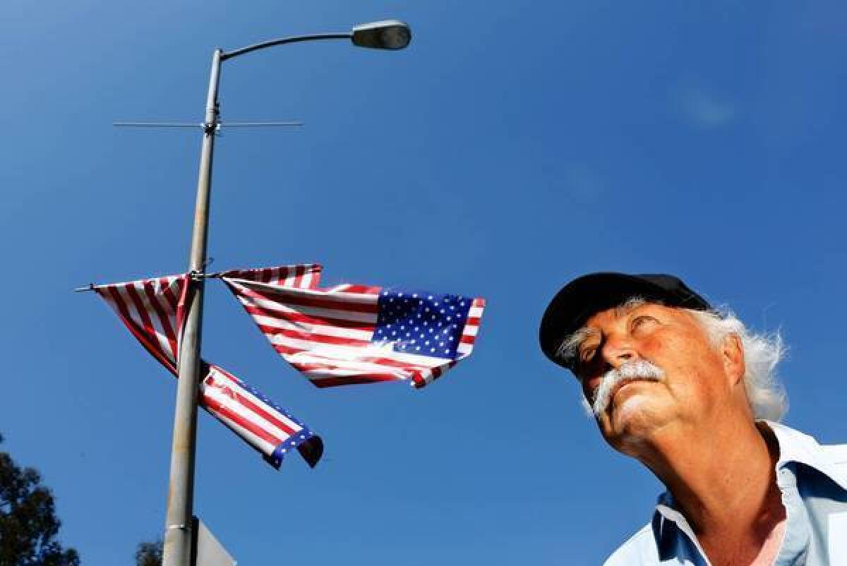 Robert Rosebrock stands near battered American flags that were hung last year in West L.A. "It was offensive and an insult to all who have defended the Flag, particularly to the patients at the VA hospital," he wrote in an opinion piece.