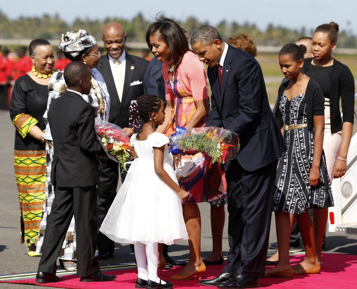 U.S. President Obama and first lady Michelle Obama receive flowers during an official arrival ceremony in Dar es Salaam