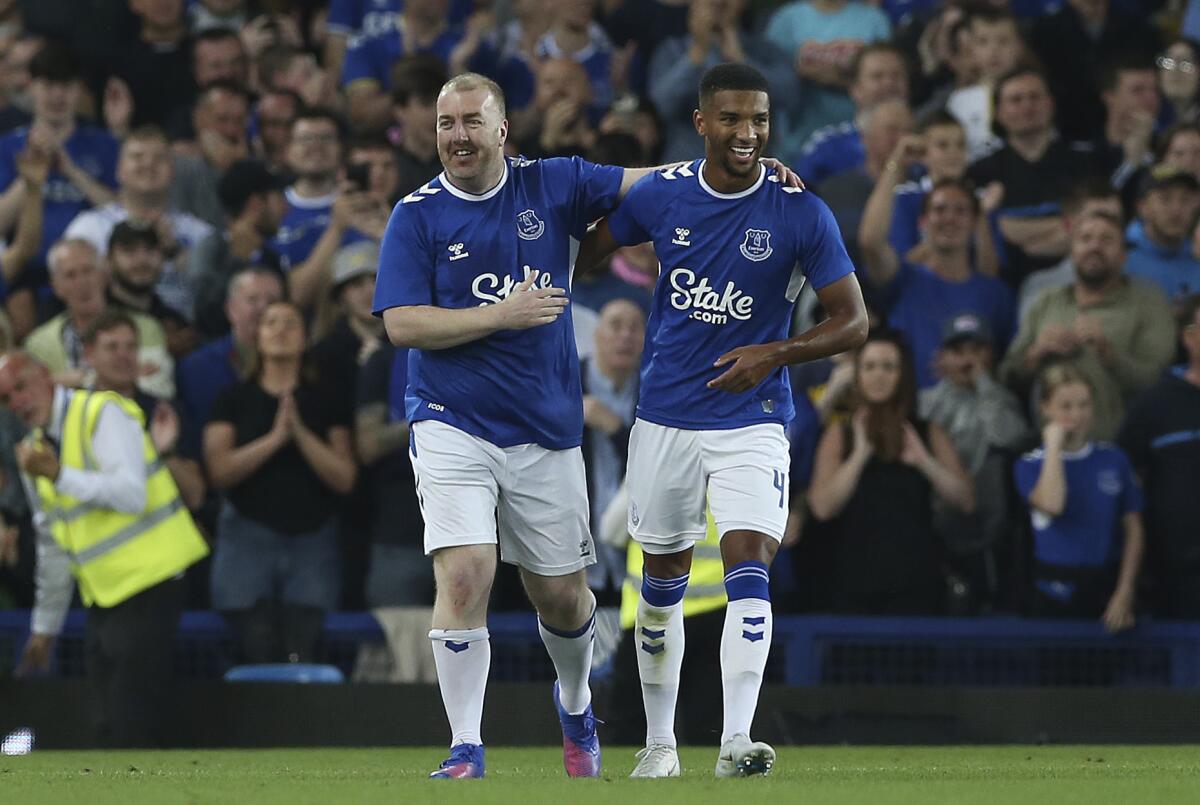 Mason Holgate, derecha, festeja con el aficionado Paul Stratton durante un partido amistoso 